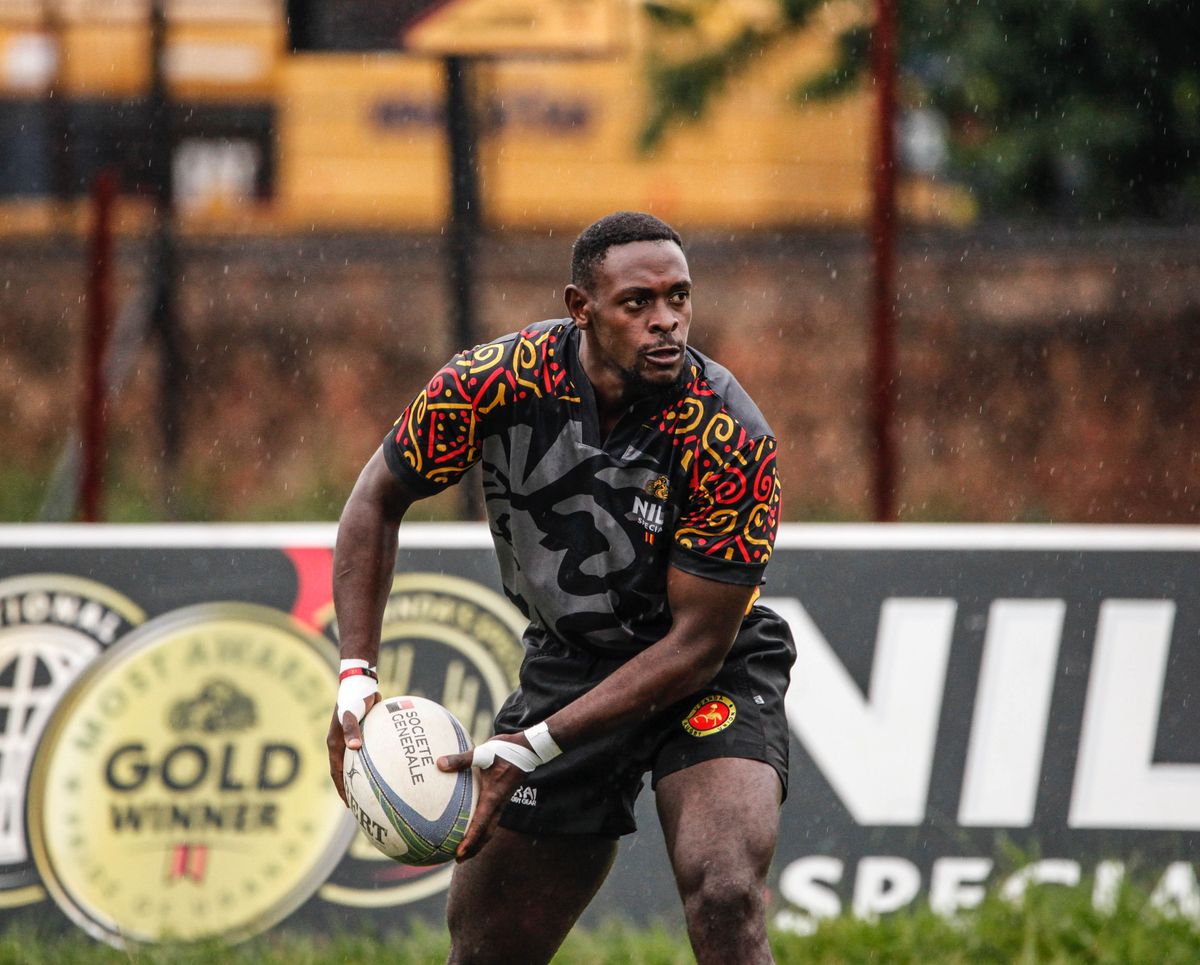 Un joueur de rugby avec le ballon sous la pluie